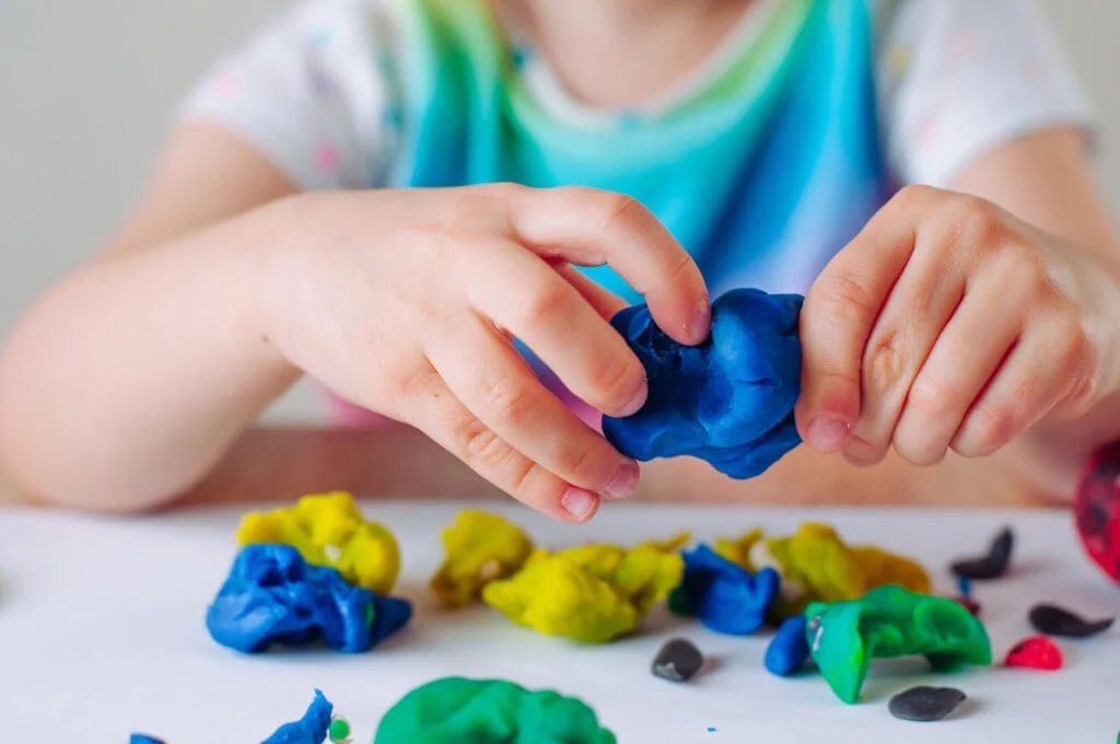 Child exploring creative learning with colorful materials